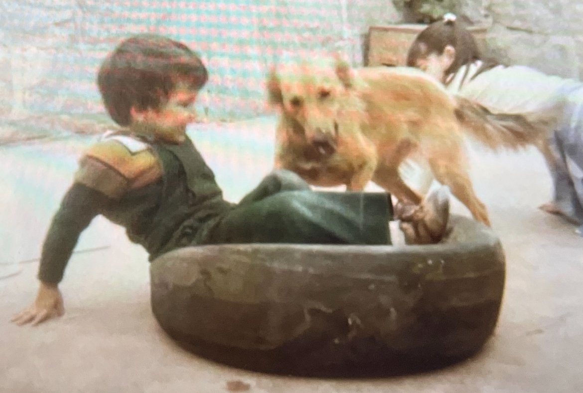 Cesar as a young child spending time with his family dog and puppies